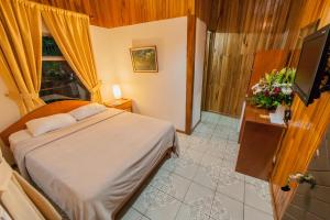 a bedroom with a bed and a window and a television at Cabinas Eddy B&B in Monteverde Costa Rica