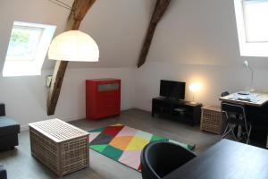 a living room with a table and a red cabinet at Le Presbytère in Menetou-Salon