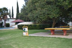 a picnic table and a sign in a park at Hotel La Joya Tulancingo in Tulancingo