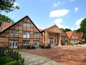 a large brick building with cars parked in front of it at Golfpark Gut Düneburg in Haren