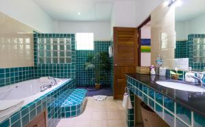ein blau gefliestes Bad mit 2 Waschbecken und einer Badewanne in der Unterkunft Sea View Luxury Villas Kata Beach in Kata Beach