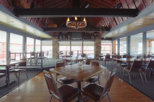 - une salle à manger avec des tables, des chaises et des fenêtres dans l'établissement Byrncliff Golf Resort, à Varysburg