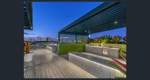 a rooftop deck with benches and a view of the city at Eastwood Apartments in Brisbane