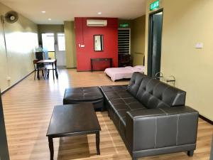 a living room with a leather couch and a table at SS Homestay Borneo Housing SL4 in Kampung Nombor Dua