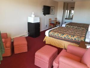 a hotel room with two beds and chairs and a tv at Travel Inn in Sunnyside