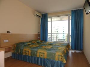 a bedroom with a bed and a large window at Bonita Hotel in Golden Sands