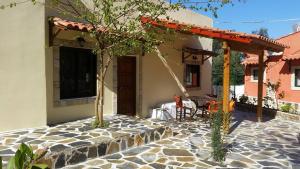 a house with a stone patio with a pergola at Villa Argo, Feakia in Agios Gordios