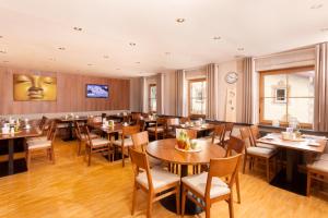 a restaurant with tables and chairs and a clock on the wall at Hotel.Pension.Golingen in Golling an der Salzach