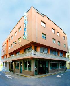 a large orange building with a sign on it at Hotel Las Viñas in Arteixo