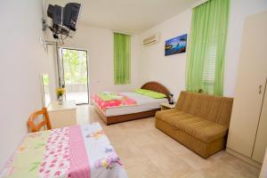 1 dormitorio con sofá, cama y ventana en Apartments Kristina Jaz Budva, en Budva