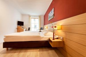 a bedroom with a large bed with a red wall at Hotel.Pension.Golingen in Golling an der Salzach