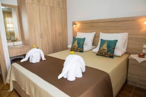 1 dormitorio con 2 cisnes hechos de toallas en una cama en Haraki Dream View, en Charaki