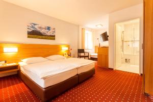 a hotel room with a large bed and a bathroom at Hotel.Pension.Golingen in Golling an der Salzach