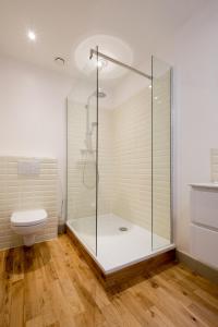 a bathroom with a glass shower and a toilet at Braamberg B&B in Bruges