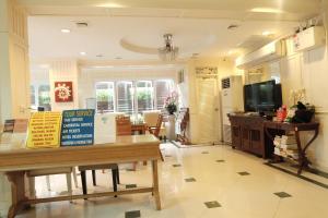 a living room with a table and a tv at Orchid Resort in Lat Krabang