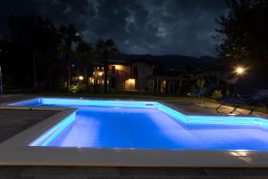 a swimming pool with blue lighting at night at Albergo Diffuso Polcenigo B.Vittorio in Polcenigo