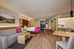 um quarto de hotel com uma cama e um sofá em Hotel Saltauserhof em Saltusio