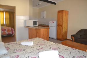 una piccola cucina e un soggiorno con tavolo di oasis guest house a East London