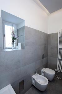 プラハにあるアパートメント ハウス ザ モダン フラットのバスルーム(トイレ、洗面台付)、窓が備わります。
