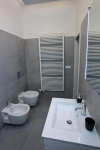 a bathroom with a white sink and a toilet at Apartment House - The Modern Flat in Prague