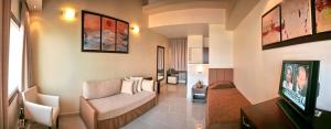 a living room with a couch and a television at Lemnos Village Resort Hotel in Platy