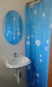 bagno con lavandino e tenda doccia blu di Skyway Hotel a Entebbe