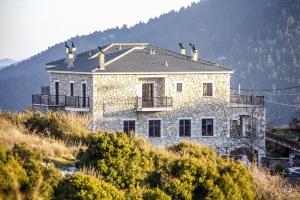 una casa de piedra en la cima de una colina en Ouranogiton Resort, en Kosmás