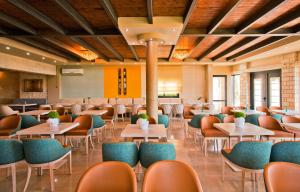 a dining room with tables and chairs at Ornella Beach Resort & Villas in Syvota