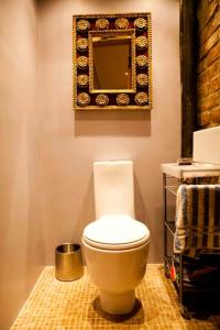 a bathroom with a toilet and a mirror on the wall at Epicurean Clerk Apartment in Edinburgh