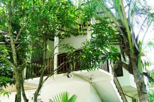 a building with a balcony with trees in front of it at Turtle Lamp in Unawatuna
