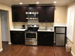 a kitchen with black cabinets and stainless steel appliances at Berkshire Motor Hotel in San Diego