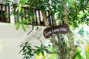Turtle Lamp في يوناواتونا: علامة على شجرة أمام المبنى