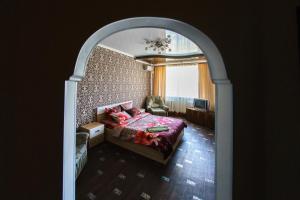 オレンブルクにあるApartment on Gagarina 27/6のアーチ道を通ってベッドルーム1室(ベッド1台、窓付)