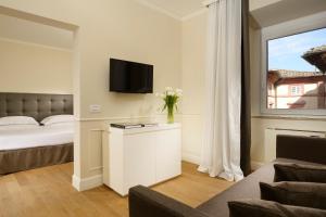 a hotel room with a bed and a tv at Locanda della Posta Boutique Hotel in Perugia