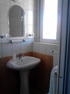 uma casa de banho branca com um lavatório e um espelho em Horváthkert Panzió és Étterem em Bogács