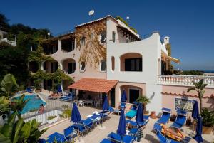 a resort with a pool and chairs and a building at Hotel Bellevue Benessere & Relax in Ischia