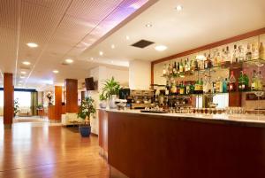 un bar avec beaucoup de bouteilles sur le mur dans l'établissement Hotel Rialto, à Grado