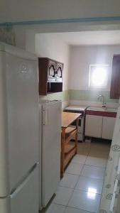 a kitchen with a refrigerator and a table in it at Casa Rustica Apart & Rooms in Cîmpineanca