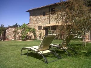タヴァルネッレ・ヴァル・ディ・ペーザにあるLa Rocca Chianti Hospitalityの建物前の芝生に座る椅子2脚