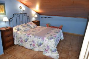 a bedroom with a bed with a floral bedspread at Apartamentos Rurales Natura in Torrejón el Rubio