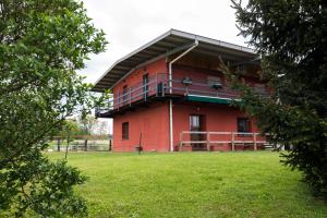 un edificio rojo con un césped verde delante de él en Agriturismo Jesson Rosamund, en Cantù