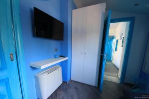 a blue room with a washing machine and a tv on the wall at La Casa Sulla Spiaggia in Flumini di Quartu