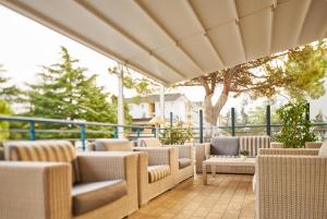 a group of chairs and tables on a patio at Hotel Rialto in Grado