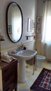 uma casa de banho com um lavatório, um espelho e um WC. em Ca' Mia Ca' Tua em La Loggia