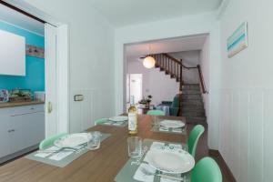 a dining room with a table and green chairs at Vilasardemarlux1 in Vilassar de Mar