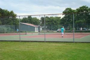 un gruppo di persone che giocano a tennis su un campo da tennis di De Kapershut a Hollum Altre 22 foto