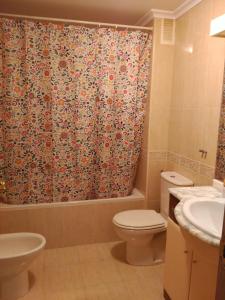 Un baño con inodoro y cortina de ducha. en Vivienda Briviesca La Vega, en Briviesca