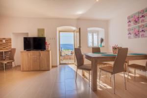 a living room with a dining room table and a television at Apartment Marija in Vrana