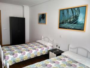 una habitación con 2 camas y una pintura de un barco en Vivienda Briviesca La Vega, en Briviesca