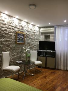 a living room with a table and chairs and a tv at Duplex Studio Traversa- Split Old Town in Split